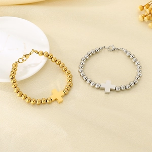 Detailed shot of gold and silver beaded cross bracelets with polished metal finish