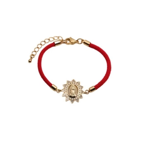 Detailed macro view of red braided bracelet with golden Virgin of Guadalupe charm