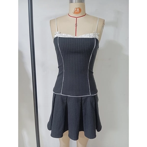 Détail d'une mini robe grise à rayures avec des volants blancs et des petits nœuds