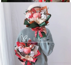 Christmas apple bouquet with reindeer antlers and snowflakes wrapping in model's arms