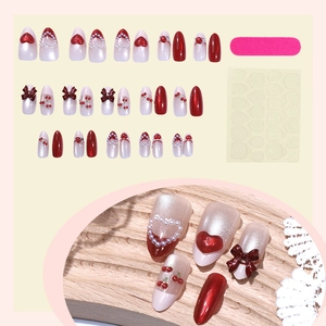 3D press-on nail kit with cat-eye finish, red hearts, pearls, and brown bow accents