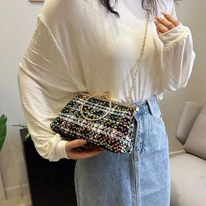 Chic evening clutch bag featuring colorful sequins and a gold metal ring handle