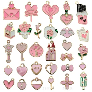 Detailed flat lay of pink enamel heart and flower charms for DIY jewelry making