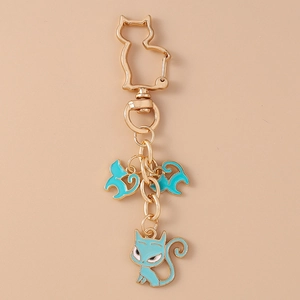 Detail of turquoise enamel cat pendants on a gold-tone feline-shaped metal keyring