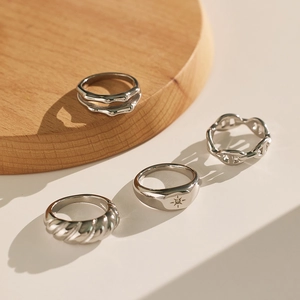 Detail view of silver stainless steel rings including link chain and star engraved band