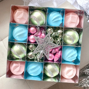 Flat lay of pink, blue, and silver Christmas ornaments with a glitter tree star