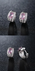 Macro view of silver hoop earrings featuring pink oval gemstones and sparkling cubic zirconia