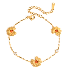 Detalle de pulsera de margaritas doradas con circonitas naranjas y placa de acero