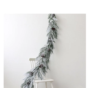 Detailed view of luxury PE Christmas garland with realistic snow and natural pinecones
