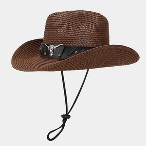 Detail of a brown woven cowboy hat with metal bull head emblem and adjustable wind rope
