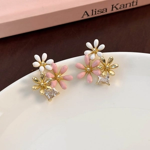 Detail view of gold-plated daisy earrings with pink petals and square zircon crystal