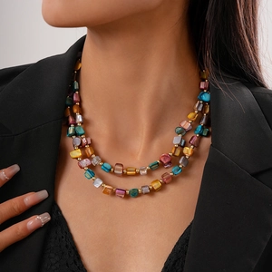 Detail of colorful irregular shell-like square beads with small gold accents on double necklace