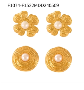 Detailed view of vintage gold-plated floral and swirl stud earrings with shell pearls