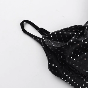 Detailed macro view of black velvet dress straps with shimmering silver sequin polka dots