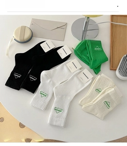 Flat lay of ribbed cotton mid-calf socks with dreamer embroidery in various colors