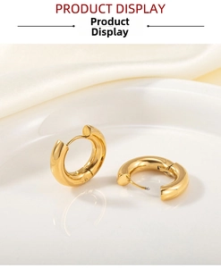 Detail of 18k gold plated stainless steel chunky hoop earrings on white porcelain