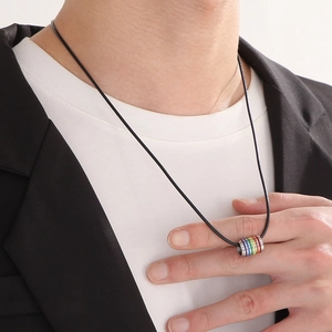 Rainbow ring pendant on black leather cord necklace worn by a male model over a white T-shirt