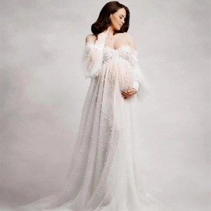 Detailed close-up of white tulle maternity dress with delicate pearl embellishments