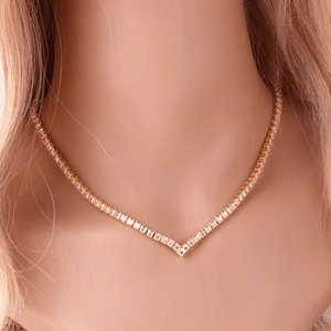 Close-up of elegant gold V-shaped necklace with shimmering cubic zirconia on neck