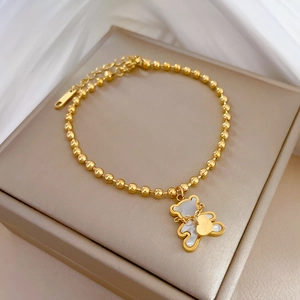 Elegant gold bead chain bracelet featuring white mother of pearl bear and heart charms