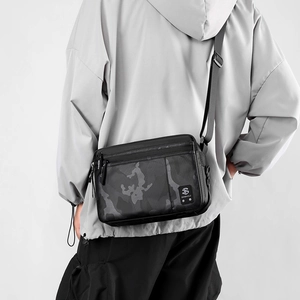 Men's black camo nylon crossbody bag with adjustable strap shown on model's back