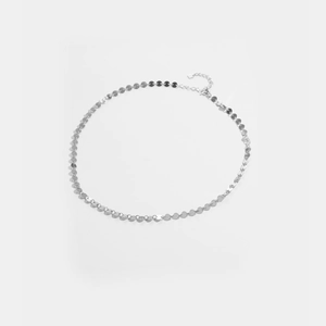 Dettaglio della collana minimalista a dischi d'argento con chiusura regolabile e lucentezza