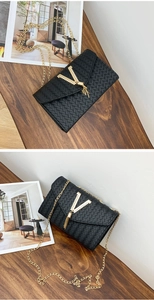 Détail d'un sac bandoulière noir tissé avec ornement en V doré et bandoulière en chaîne