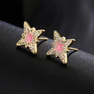 Star-shaped gold earrings with pink enamel center and zircon stones on black leather