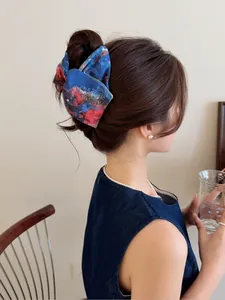 Détail d'une pince à cheveux tie-dye bleu et rouge sur modèle avec texture peinture à l'huile