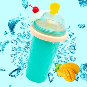 Portable turquoise slushy maker cup with cream lid and cherry decoration on splash background