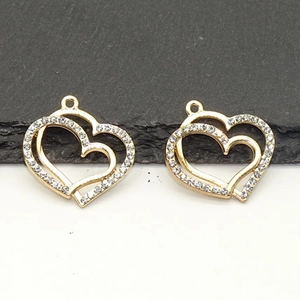 Detail showing two golden double-heart pendants with sparkling rhinestones and a smooth finish