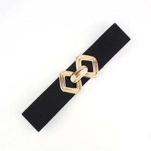 Détail de la boucle géométrique dorée sur une large ceinture élastique noire pour femme