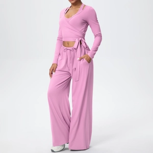 Détails de l'ensemble de yoga rose avec haut cache-cœur à nouer et pantalon à cordon