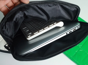 Internal view of black padded laptop sleeve showing storage space for keyboard and device