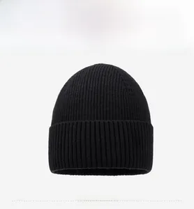 Détail de face du bonnet en maille noire avec petite étiquette et texture côtelée