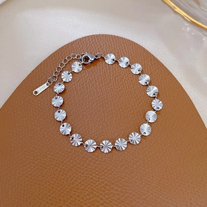 Dettaglio del bracciale in acciaio titanio argento con dischi testurizzati e chiusura
