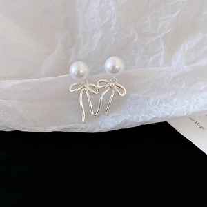 Détail de boucles d'oreilles nœud de style français avec perles blanches rondes