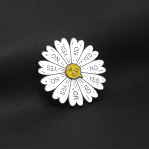 Close-up of daisy enamel pin with Yes or No text on a black leather background
