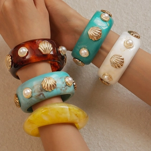 Detail of retro resin bangles with gold shell accents and pearl inlays in various colors