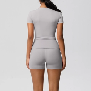 Back view of a grey women's yoga set featuring slim fit T-shirt and high waist shorts