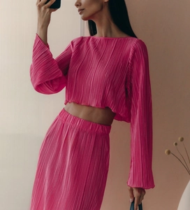 Detailed view of the pleated texture on rose pink flared sleeve top and skirt set
