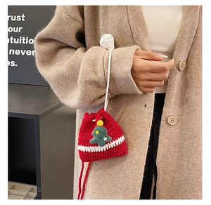 Detail of red handmade crochet Christmas tree drawstring bag with white pom-poms