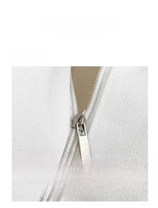 Detailed close-up of smooth silver metal zipper on white canvas bag with neat stitching