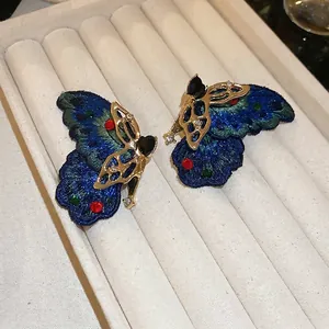 Handcrafted asymmetric butterfly stud earrings with colorful embroidery and gems