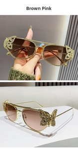 Detail of gold metal sunglasses with crystal butterfly decor and brown pink gradient lens