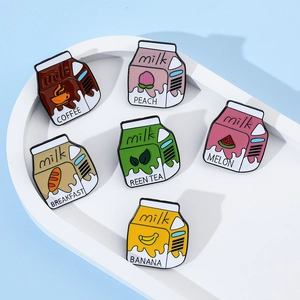 Collection of six cute cartoon milk carton enamel pins in various fruit flavors on a tray
