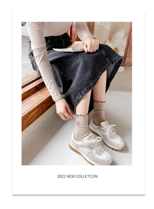 Close-up of beige ruffled socks with floral embroidery paired with casual sneakers