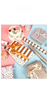 Detail of gold foil gift wrapping paper with stripes and dots for birthday presents