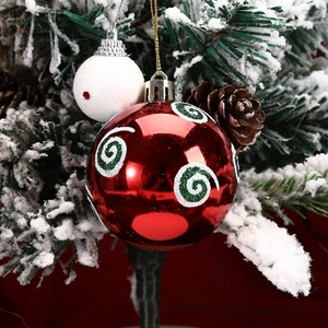 Detail of red spiral glitter Christmas ball and white frosted ornament on snowed branch