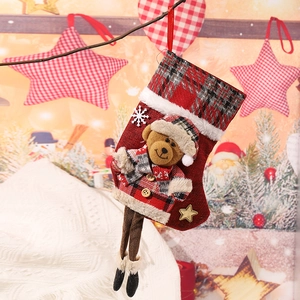 Detail of red plaid Christmas stocking with 3D plush bear and embroidered holiday text